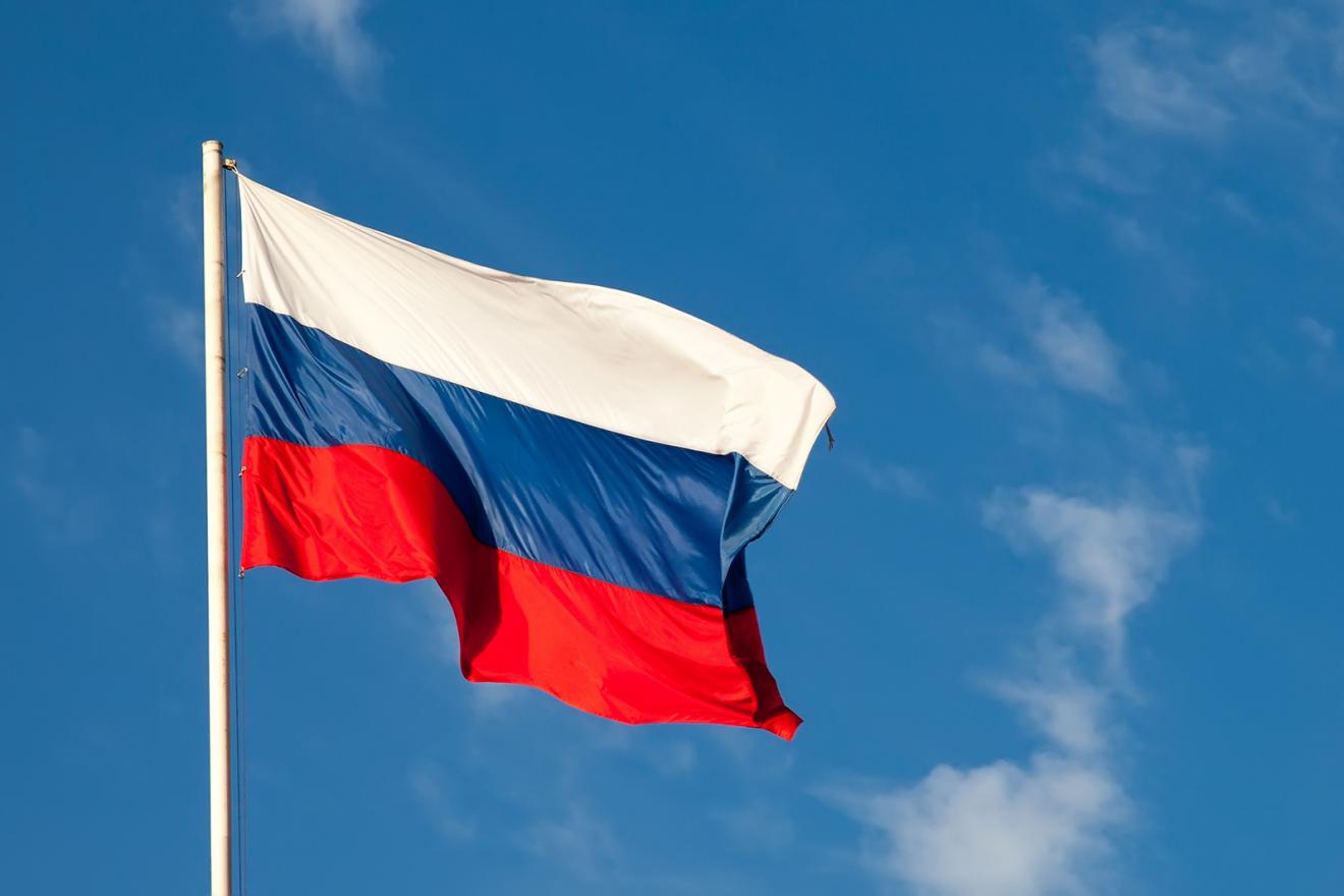 Russische Flagge weht im Wind mit ein paar Wolken und blauem Himmel